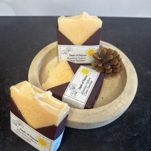 Tallow Soap made by dash of nature. Features 3 tallow soaps arranged neatly with a shallow wooden dish and a pinecone decoration